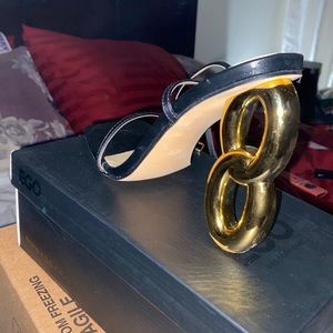 A pair of black strap gold heels